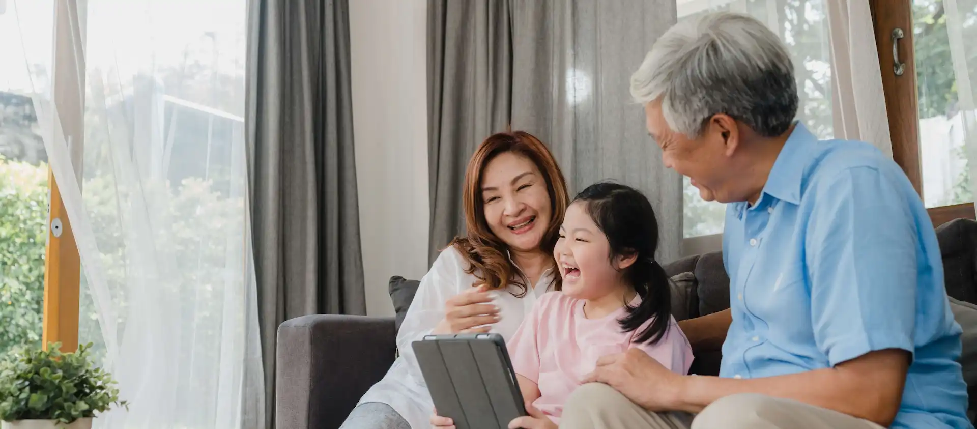 grandparents and granddaughter using tablet