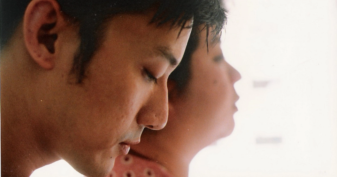 A film still from "12 Storeys" showing two young Asian characters in profile, looking pensive and introspective.