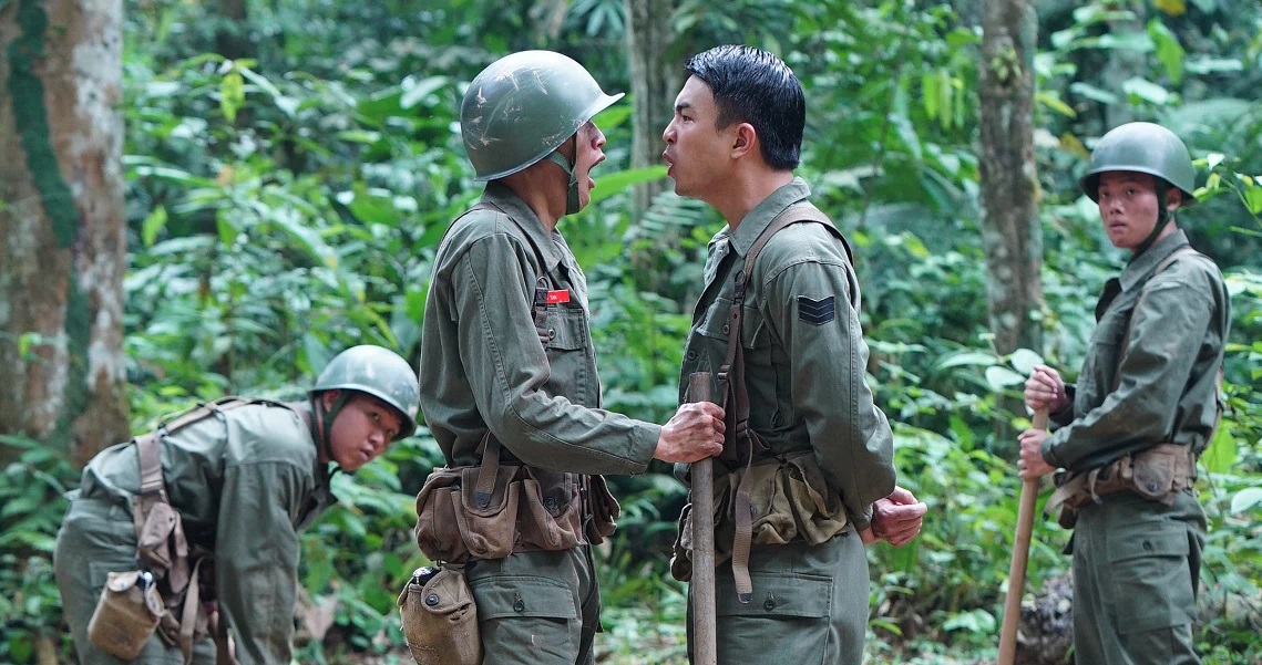 Intense scene from "2359: The Haunting Hour" shows soldiers in conflict amidst lush jungle setting, capturing the film's tense atmosphere.