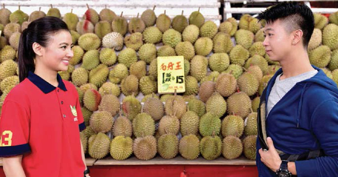 A scene from the film "4Love" showing a man and woman at a durian stall, surrounded by numerous durian fruits.