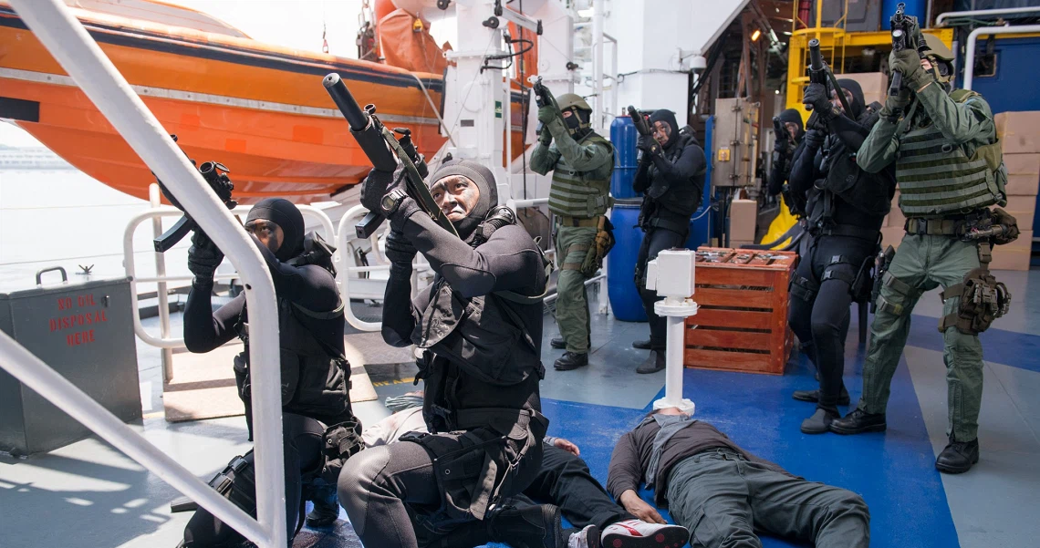 Soldiers in combat gear training on a ship deck in a scene from the film Ah Boys To Men 3 Frogmen.