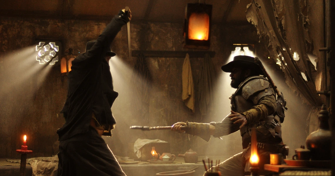 A dramatic scene from the film Buffalo Boys shows two silhouetted figures engaged in a sword fight, illuminated by candlelight and lanterns.