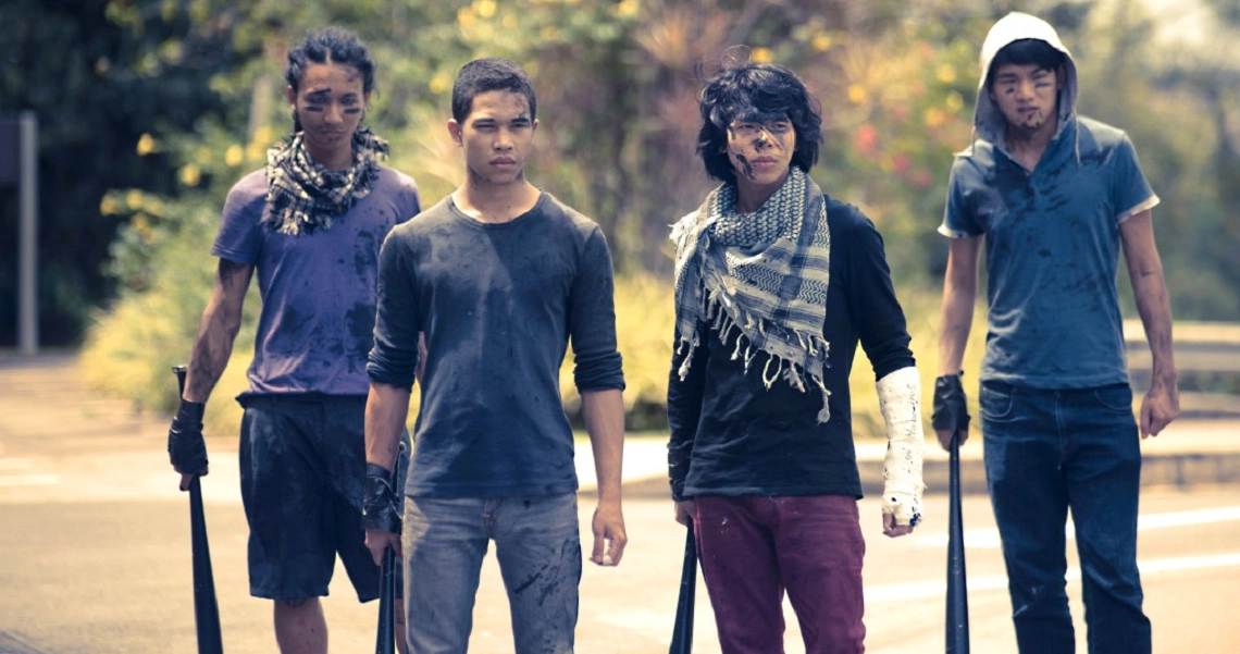 A film still from Faeryville showing four young characters walking together, dressed in grungy outfits with determined expressions.