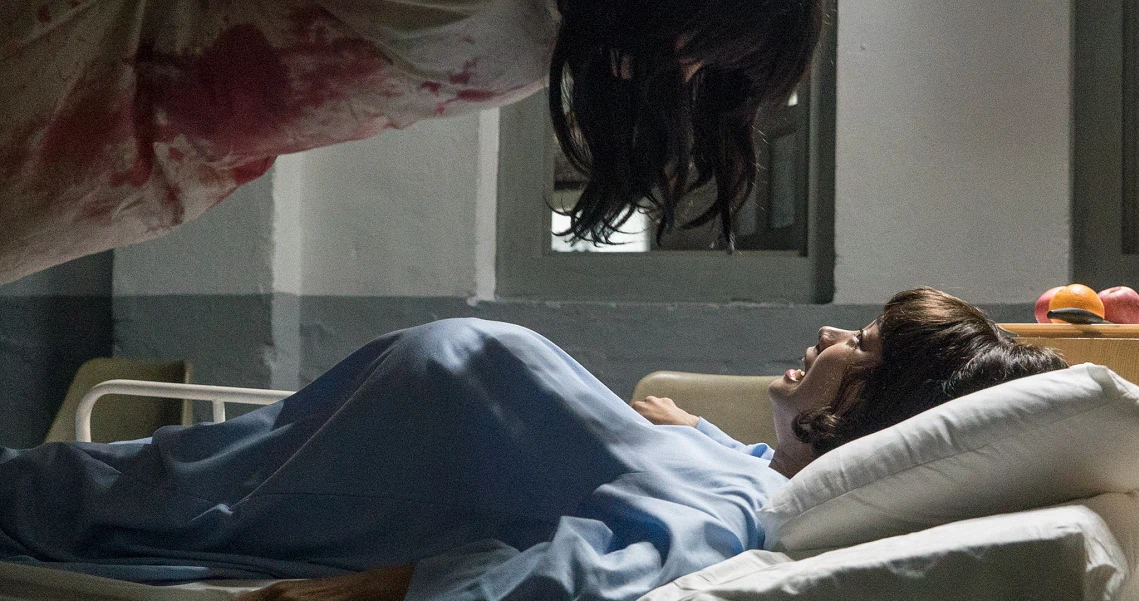 A patient lies in a hospital bed in a scene from the film Hell Hole, depicting a gritty and intense medical environment.