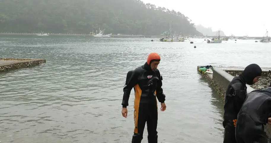 A diver standing at the foot of the reservoir, a still from I Want To Go Home.