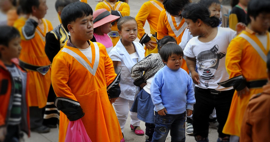 A group of children in colorful clothing gather for a scene from the film "Little People Big Dreams," showcasing diversity and youth.