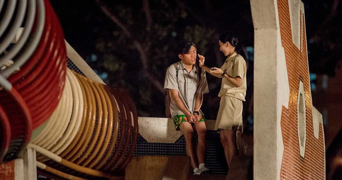 A scene from the film Lucky Boy showing two young people in conversation at night, with colorful lanterns in the foreground.