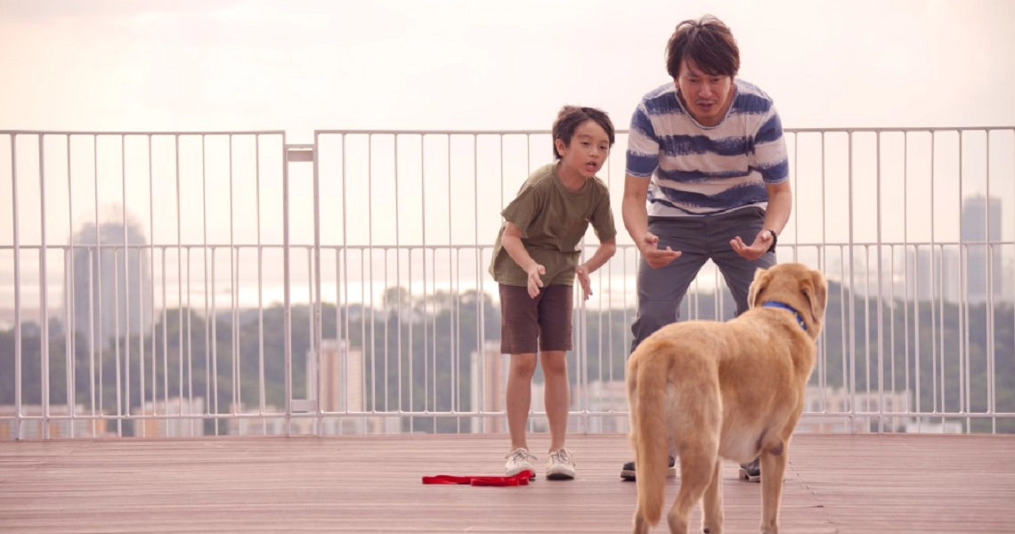 A scene from the Singaporean film 'My Dog Dou Dou' showing a character interacting with a dog, likely Dou Dou.