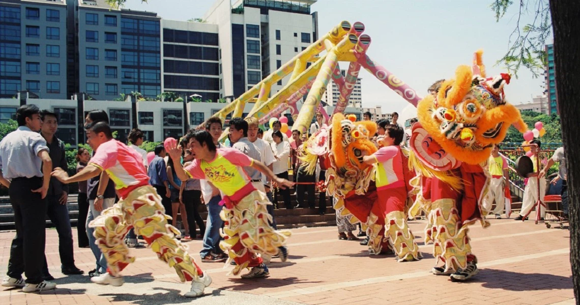 A scene from the Singaporean film 'The Best Bet' showing characters engaged in a tlion dance sequence.