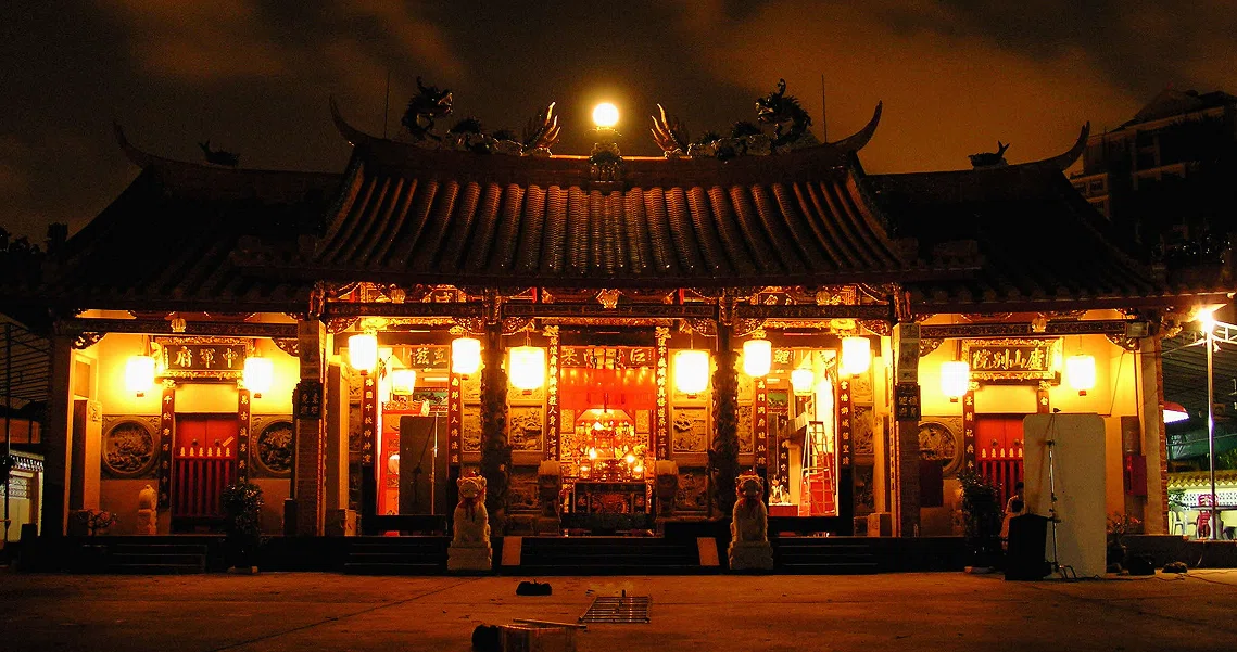 Night scene from "The Maid" film showing a brightly lit traditional Chinese temple with red lanterns and ornate architecture.