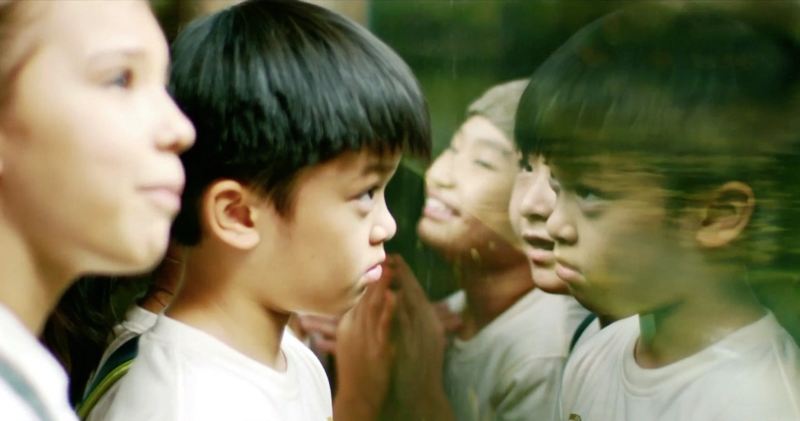 A young boy stands among other children in a scene from the Singaporean film "The Wayang Kids".