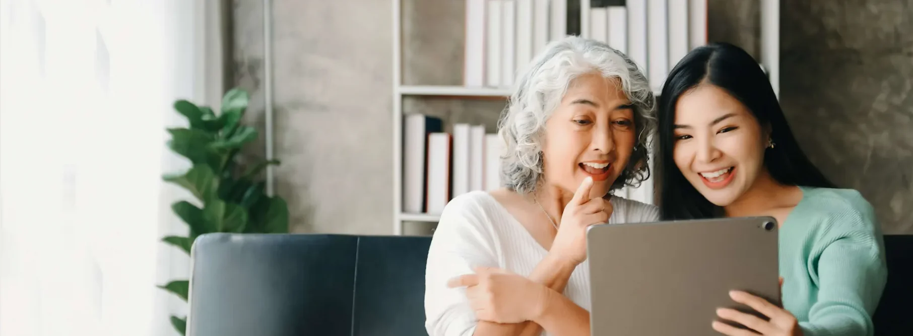 grandma and granddaughter using a device together.