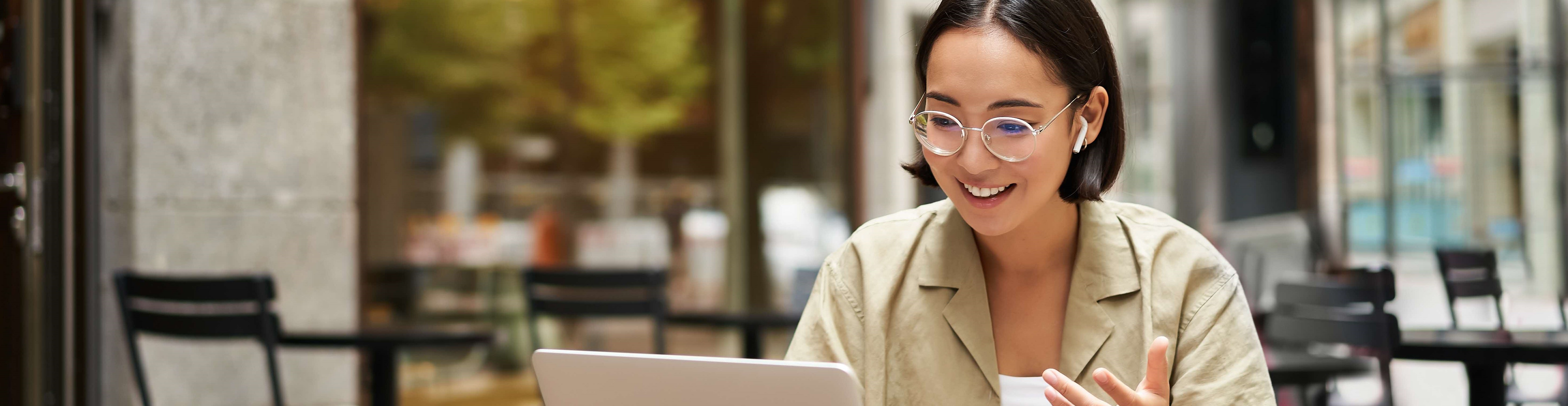 A woman smiling while taking an online call, subtly hinting at the incorporation of tech solutions.